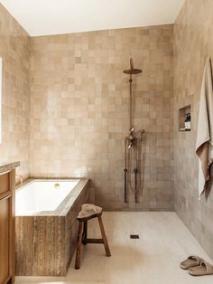 a bath room with a large tub and a wooden stool