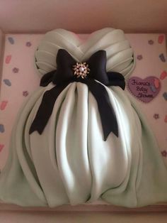 a cake in the shape of a dress with black and white bows on it's back