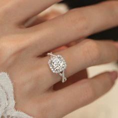 a woman's hand with a diamond ring on top of her finger and an engagement band