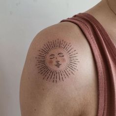 a woman with a sun tattoo on her shoulder