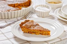 a piece of pie sitting on top of a white plate next to other plates and bowls