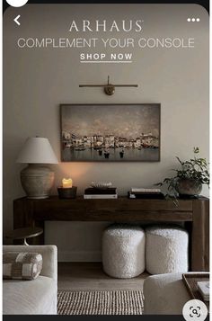 a living room with white furniture and a painting on the wall above it that says, shop now