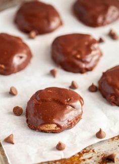 chocolate covered cookies sitting on top of parchment paper