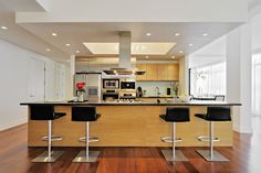 a kitchen with two bar stools and an island in the middle of the room