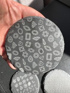 a person holding a rock with different designs on it