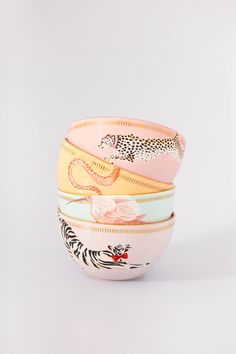 three bowls with different designs on them sitting side by side in front of a white background