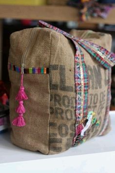 a burlocked bag with tassels on it sitting on a table