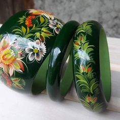 two green vases with flowers painted on them