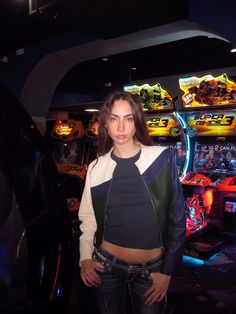 a woman standing in front of a video game machine with her hands on her hips