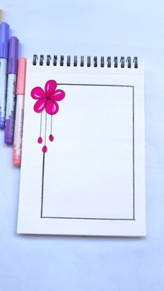 a notebook with a flower drawn on it next to crayons