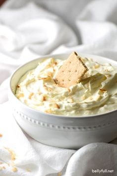 a white bowl filled with whipped cream and crackers