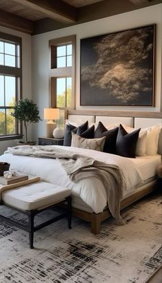 a large bed sitting in a bedroom next to two windows and a painting on the wall