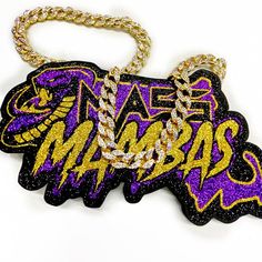 a purple and gold keychain with the word mambas on it