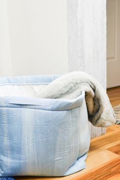 a dog laying in a bed on the floor next to a rug and door way