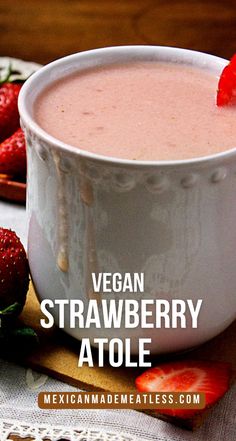 a close up of a bowl of food with strawberries on the side and text overlay that reads vegan strawberry atole