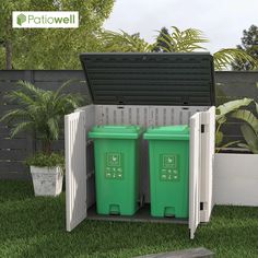 two green trash cans sitting in the back of a wooden storage box on top of grass