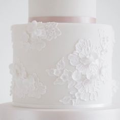 a white wedding cake with flowers on it