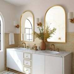 a bathroom with two sinks and mirrors on the wall next to each other in front of an arched window