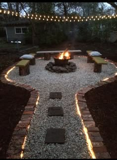 a fire pit surrounded by stones and lights