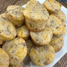 a white plate topped with muffins on top of a wooden table