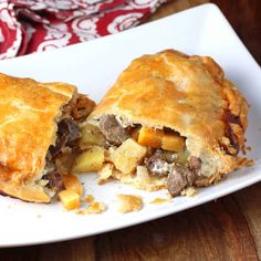 a piece of meat and potato pie on a white plate next to a red napkin