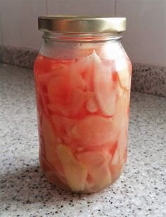 a jar filled with pickles sitting on top of a counter