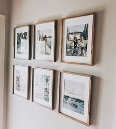 four framed photographs hang on the wall above a bed