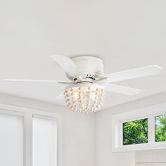 a white ceiling fan with lights in a room