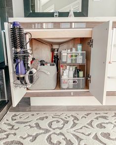 an open cabinet in the middle of a living room filled with personal care items and cleaning supplies