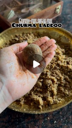 a person holding something in their hand on top of a gold plate with brown stuff