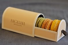 an open box filled with macaroons on top of a bed