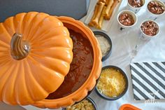 a table topped with lots of food next to bowls filled with dips and pretzels