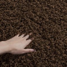 a person's hand on top of a brown carpet that looks like it has been washed