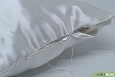 a white pillow that has been sewn with some thread on it and is laying next to the pillow