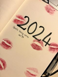 a notebook with red lipstick on it and the number twenty four in front of it