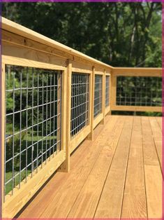 a wooden deck with metal railings and windows on the top level, along with trees in the background