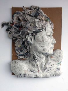 a piece of art that looks like a woman's head with newspaper all over it