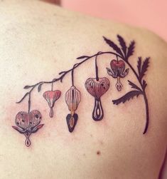 a woman's back with flowers and leaves on her left shoulder, tattoo style