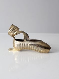 a silver shoe shaped object sitting on top of a white table