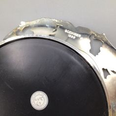 a black and silver plate with a white emblem on it