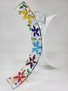 a glass vase with flowers painted on it's side and an upside down design