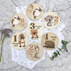 six wooden buttons with animals and numbers on them, sitting on a lace tablecloth