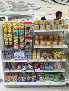 the shelves are filled with many different types of snacks and candy in their display cases