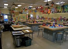 a classroom filled with lots of desks covered in magnets and paper art work