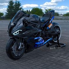 a black motorcycle parked on top of a brick road