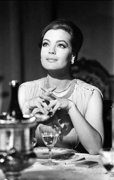 a woman sitting at a table with a glass in front of her