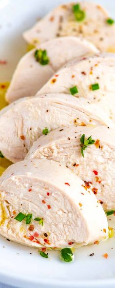 sliced chicken breast with herbs and oil on a white plate