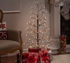 a small christmas tree with lights and presents