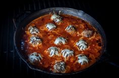 a skillet filled with meatballs and sauce on top of a grilling pan