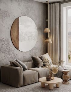 a living room filled with furniture and a round mirror on the wall above it's windows